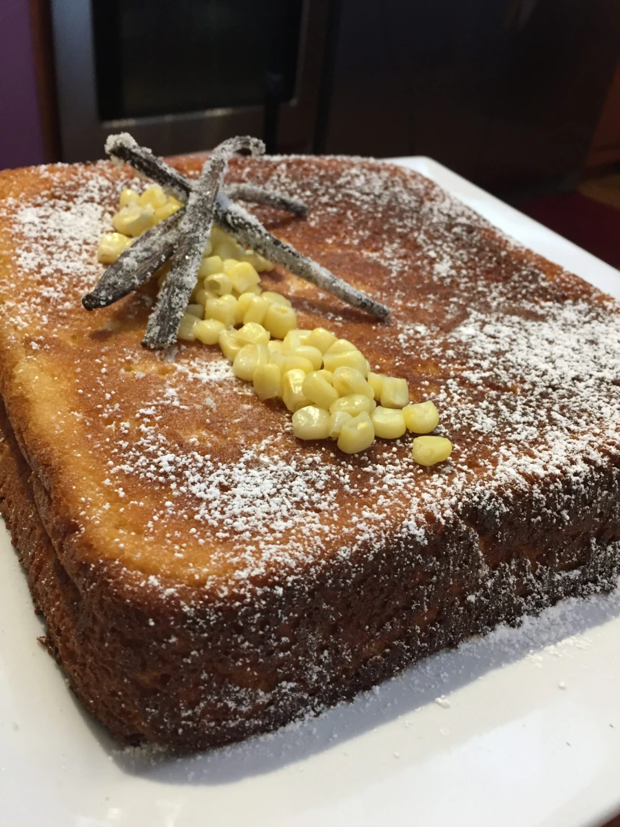 Corn Bread 15 Portion of corn bread decorated with corn kernels and powdered sugar, accompanied by eggnog sauce