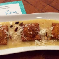 Raviolis de pimiento asado acompañados de salsa Beurre Blanc y decorados con piñones tostados.
