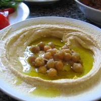 Hummus 28 Hummus casero cremoso servido con aceite de oliva y pimentón