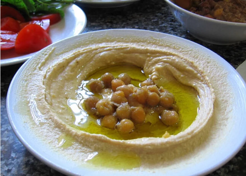 Hummus casero cremoso servido con aceite de oliva y pimentón