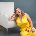 Sobre MI 3 Gina Whitley mostrando uno de sus recetarios de cocina con recetas gourmet.
