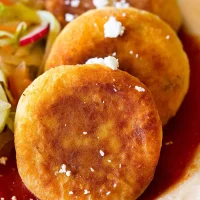 Receta de tortas de papa con queso doradas y crujientes servidas con ensalada fresca