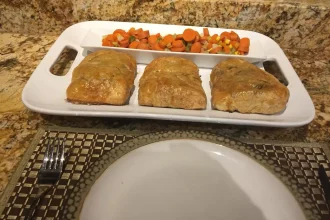 Salmón Wellington cortado mostrando el interior de salmón rosado con espinacas y hojaldre dorado