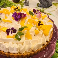 Pay de Mango 20 Pay de mango con base crujiente, relleno cremoso y decoración de crema batida, mango fresco y flores comestibles