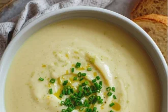 Imagen de Crema de poro y papa con toque de trufa servida en plato