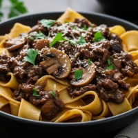 Pappardelle con ragú de setas y vino tinto servido en plato hondo