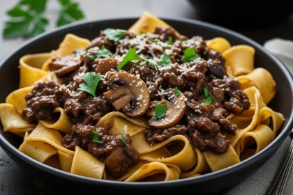 Pappardelle con ragú de setas y vino tinto servido en plato hondo