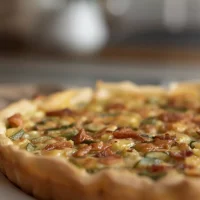 Imagen de Quiche de poro y tocino servida en plato