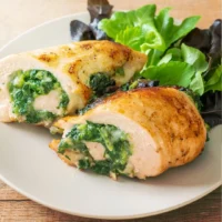 Rollo de pechuga de pollo cortado mostrando relleno verde