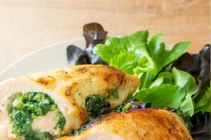 Rollo de pechuga de pollo cortado mostrando relleno verde