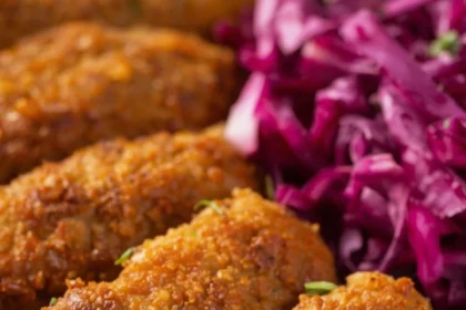 Tiras de pollo dorado sobre ensalada de col morada