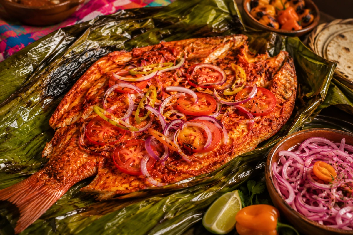 Pescado tikin xic con achiote, naranja agria y cebolla morada 28 Pescado Tikin Xic marinado con achiote y horneado en hoja de plátano